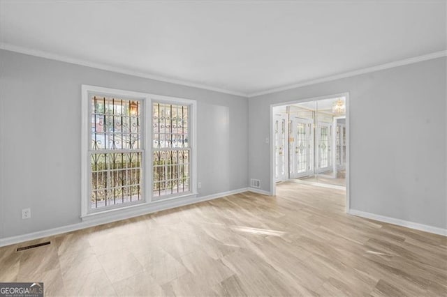 unfurnished room featuring visible vents, baseboards, and ornamental molding