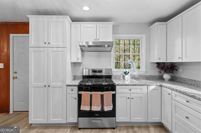 kitchen featuring stainless steel gas range oven, light wood-style flooring, white cabinets, and under cabinet range hood