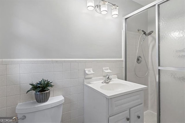 bathroom with wainscoting, toilet, a shower stall, and vanity