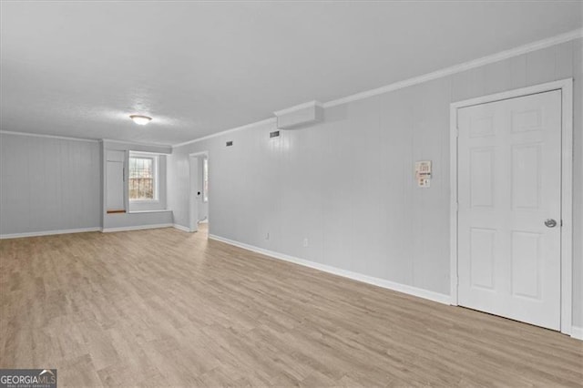 unfurnished living room featuring light wood-type flooring, baseboards, and ornamental molding