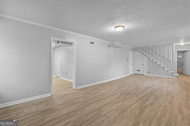 basement with wood finished floors, crown molding, a textured ceiling, and stairs