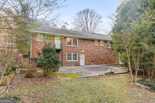 back of property with a patio and brick siding