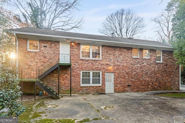 back of house with brick siding and stairway