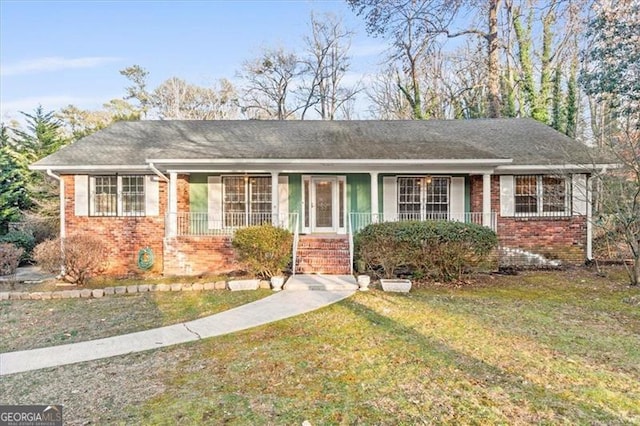 single story home featuring a front yard, a porch, and brick siding