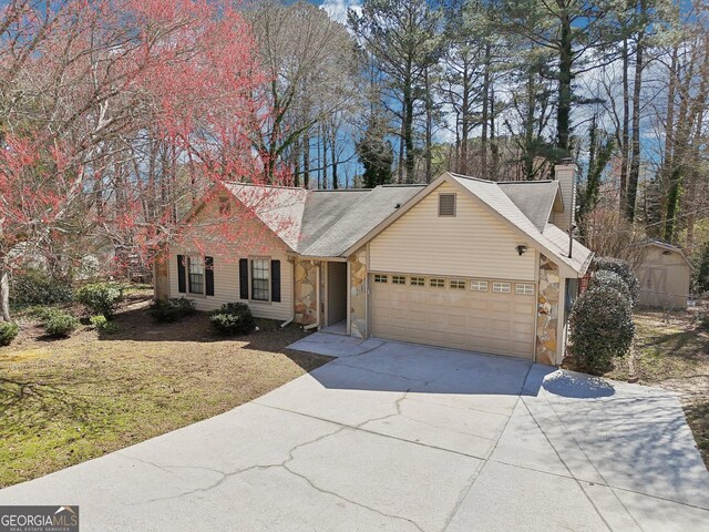 view of front facade featuring a garage, stone siding, driveway, and a chimney