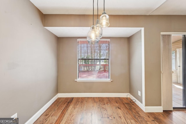 spare room with wood-type flooring and baseboards