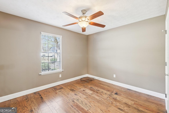 empty room featuring wood-type flooring, ceiling fan, a textured ceiling, and baseboards