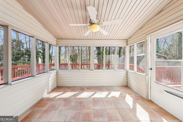 unfurnished sunroom with a healthy amount of sunlight, ceiling fan, and lofted ceiling