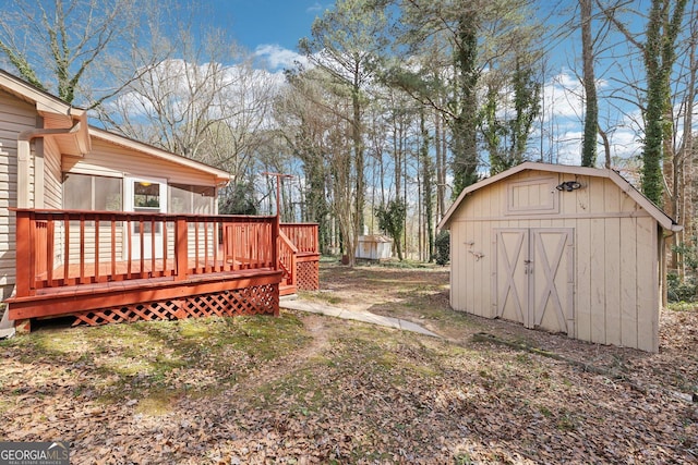 view of yard with an outbuilding, a shed, and a wooden deck