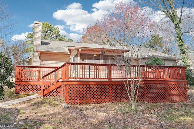 rear view of house featuring a deck and a chimney