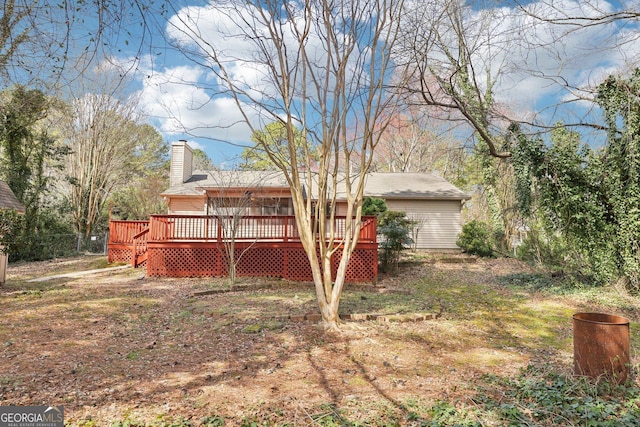 rear view of house featuring a chimney and a deck