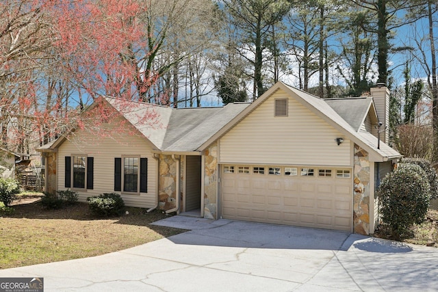 view of front facade with an attached garage, stone siding, a chimney, and concrete driveway