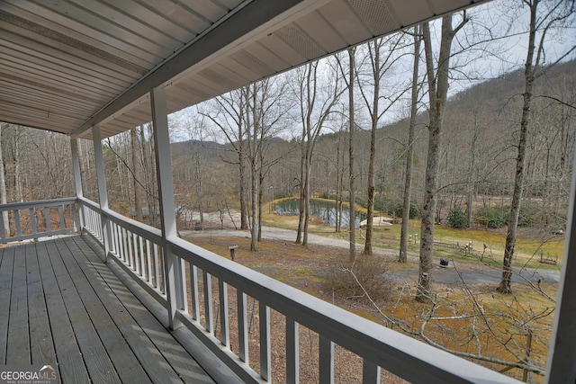 wooden terrace with a water view and a forest view