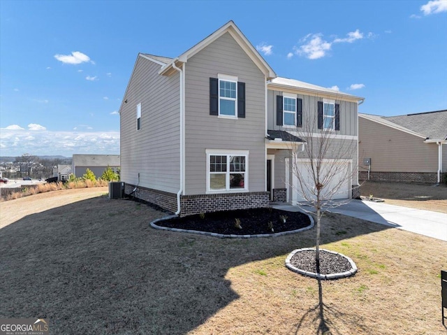 traditional-style house featuring concrete driveway, brick siding, an attached garage, and central air condition unit