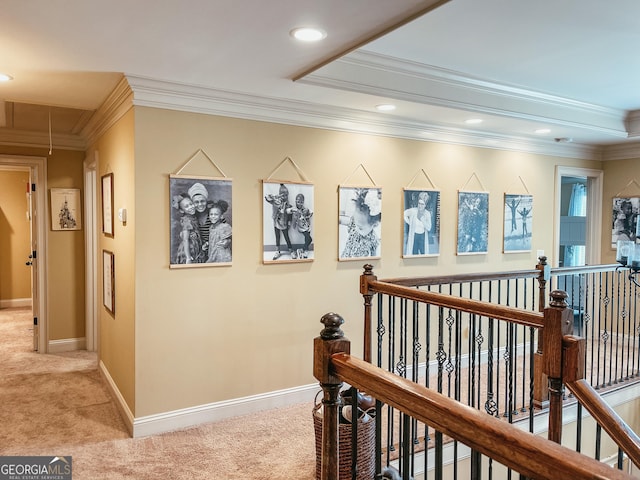 hallway with ornamental molding, carpet, an upstairs landing, and attic access