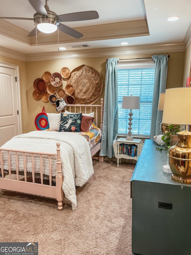 bedroom featuring visible vents, ceiling fan, carpet, a tray ceiling, and crown molding