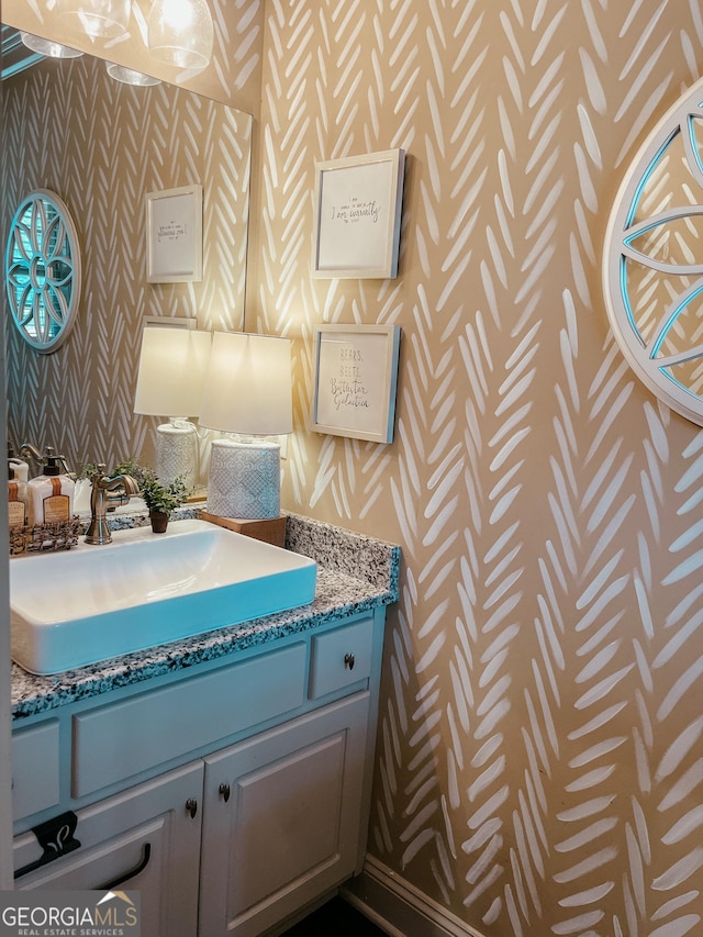 bathroom featuring vanity and wallpapered walls