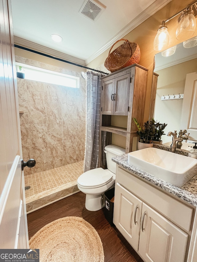 full bath with toilet, ornamental molding, wood finished floors, and visible vents