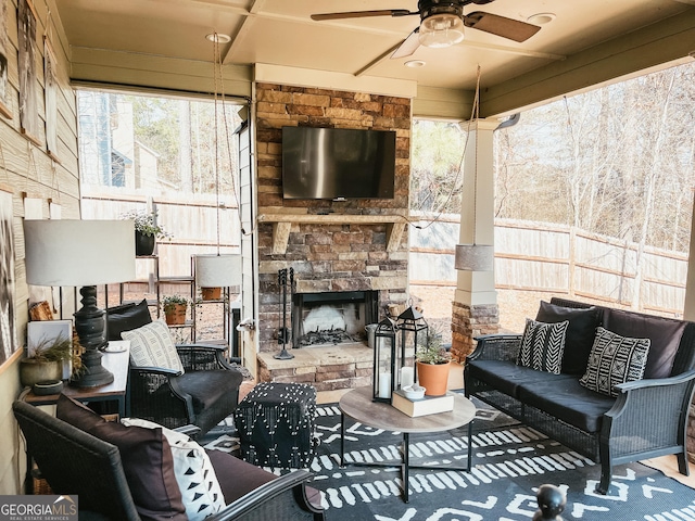 exterior space with an outdoor stone fireplace and ceiling fan