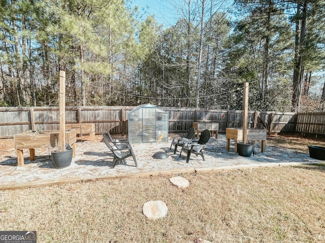 view of yard with a fenced backyard, an exterior structure, and an outdoor structure