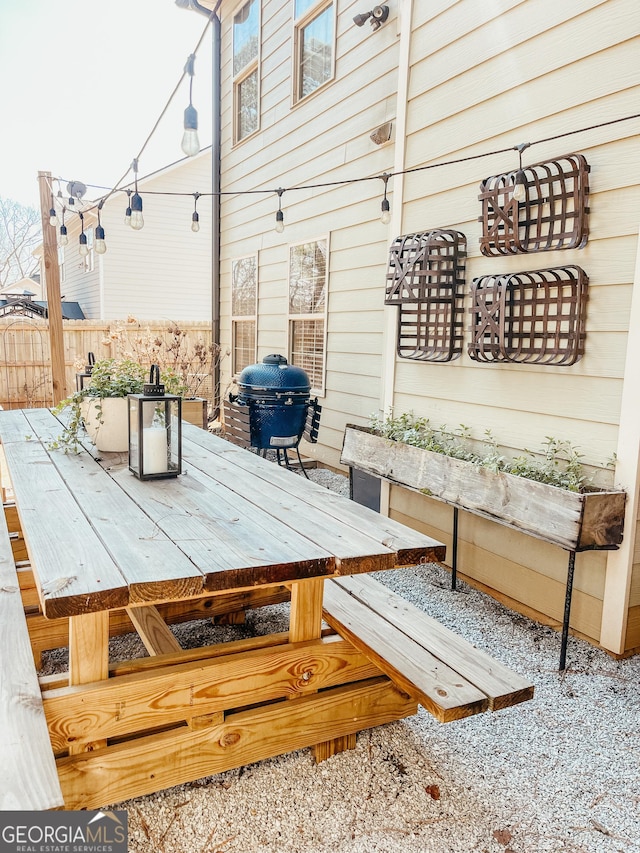 view of patio featuring outdoor dining space, a grill, and fence