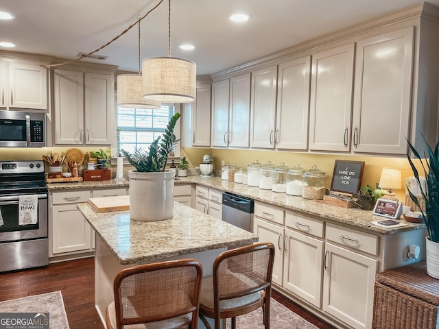 kitchen featuring appliances with stainless steel finishes, light stone counters, dark wood-style flooring, pendant lighting, and recessed lighting