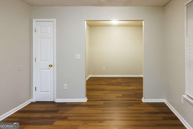 unfurnished room with wood finished floors and baseboards