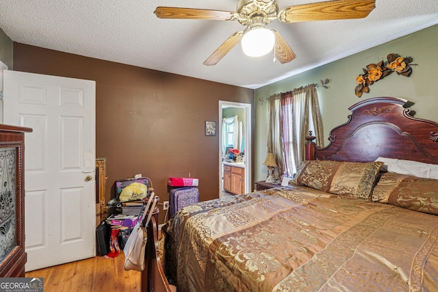 bedroom with a textured ceiling, light wood-type flooring, and a ceiling fan