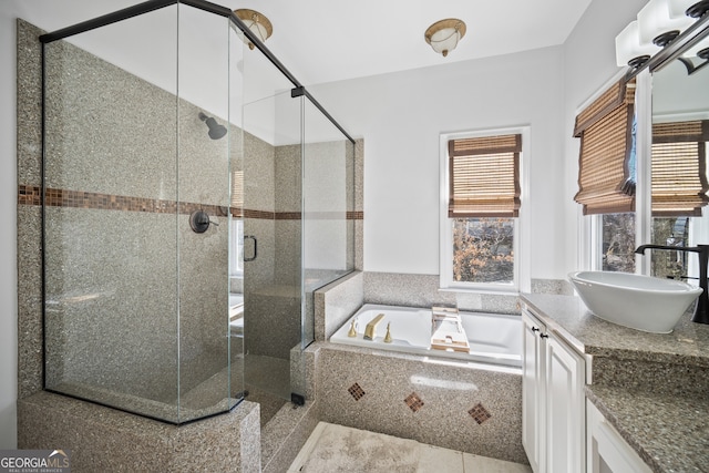 bathroom featuring a bath, a shower stall, and vanity