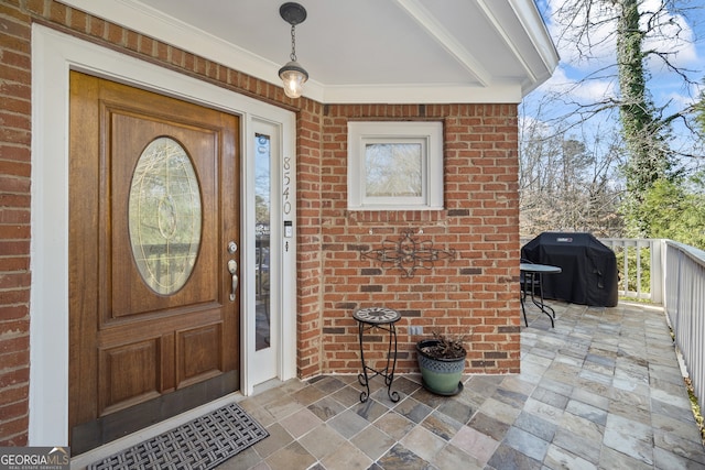 entrance to property featuring brick siding