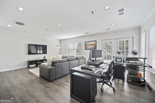 office featuring baseboards, wood finished floors, visible vents, and ornamental molding