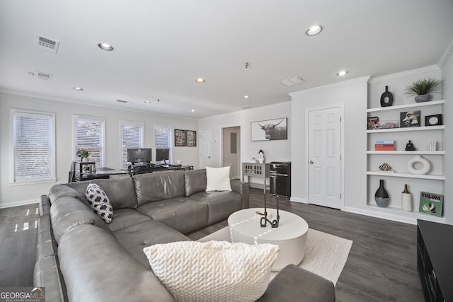 living area with visible vents, dark wood finished floors, and crown molding