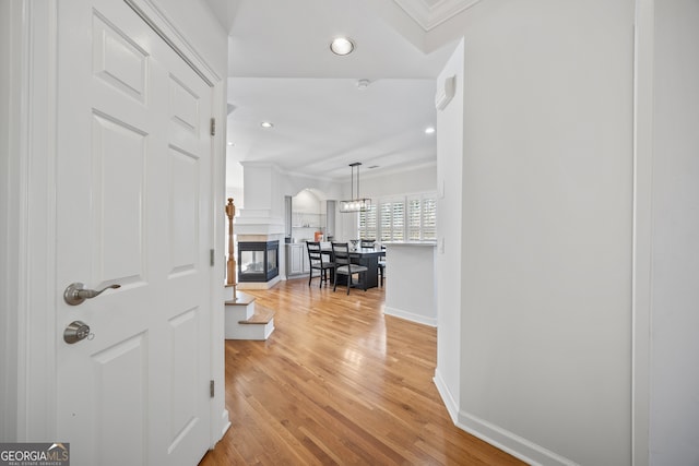 hall featuring recessed lighting, light wood-style flooring, baseboards, and ornamental molding