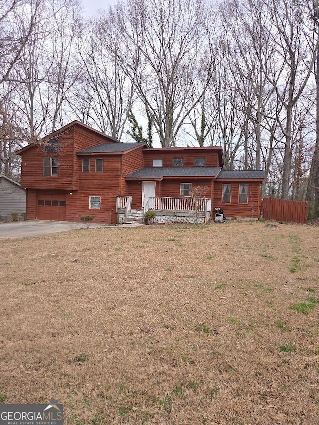 view of front facade featuring aphalt driveway, a front yard, fence, and an attached garage