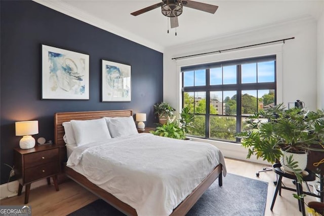 bedroom with ornamental molding, ceiling fan, and wood finished floors