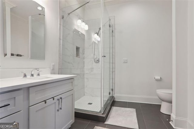 full bath featuring toilet, a shower stall, vanity, baseboards, and tile patterned floors