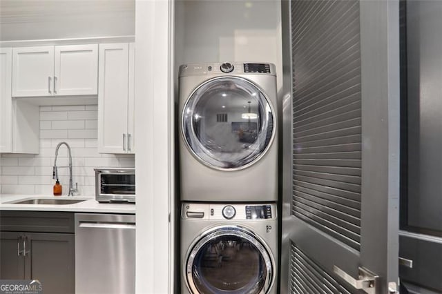 clothes washing area with laundry area, a toaster, a sink, and stacked washer / drying machine