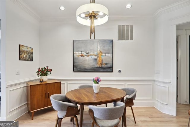 dining area with visible vents, a decorative wall, crown molding, and recessed lighting