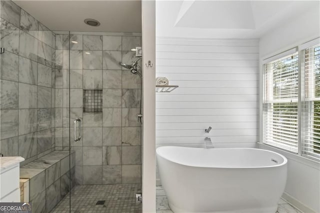 bathroom with a freestanding bath, marble finish floor, a shower stall, and a healthy amount of sunlight