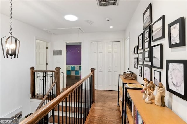 hallway with recessed lighting, visible vents, attic access, an upstairs landing, and wood finished floors