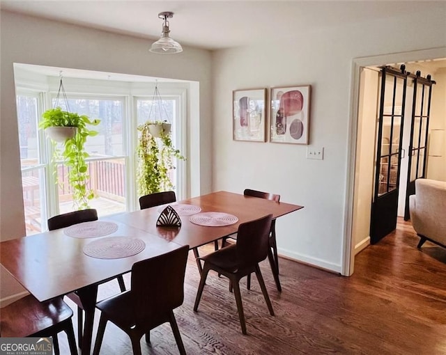 dining area with baseboards and wood finished floors