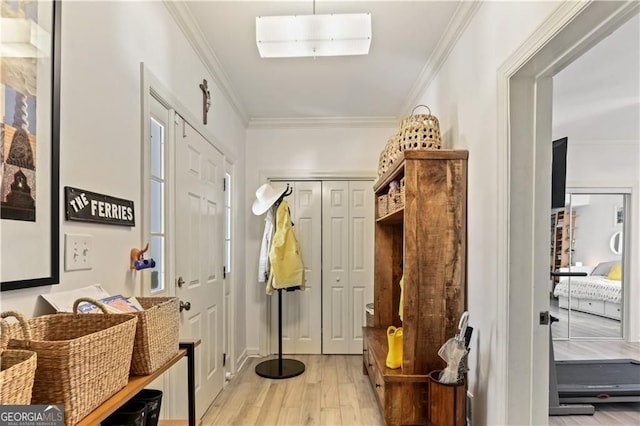 mudroom featuring light wood-style flooring and crown molding