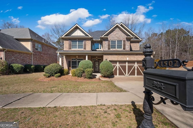 view of front of home featuring a garage, driveway, brick siding, and a front yard