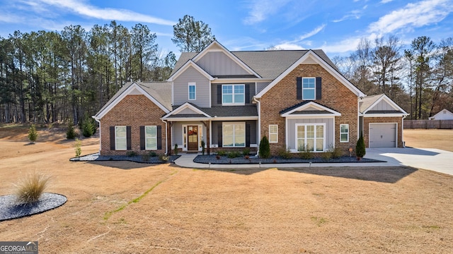 view of front of property with driveway, a garage, brick siding, fence, and a front yard