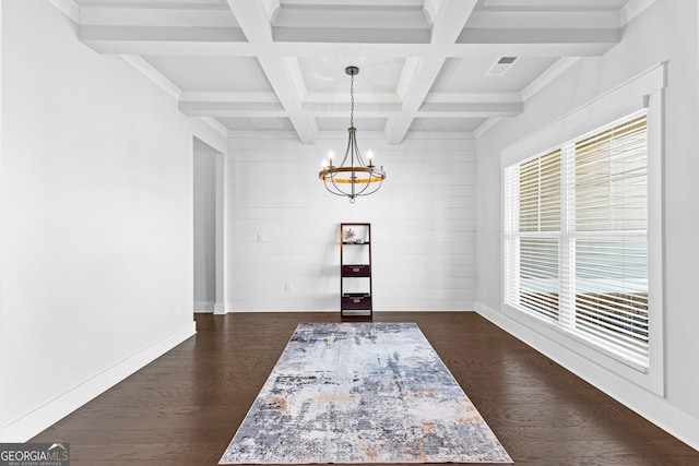 unfurnished dining area with a notable chandelier, dark wood-style flooring, coffered ceiling, visible vents, and beamed ceiling