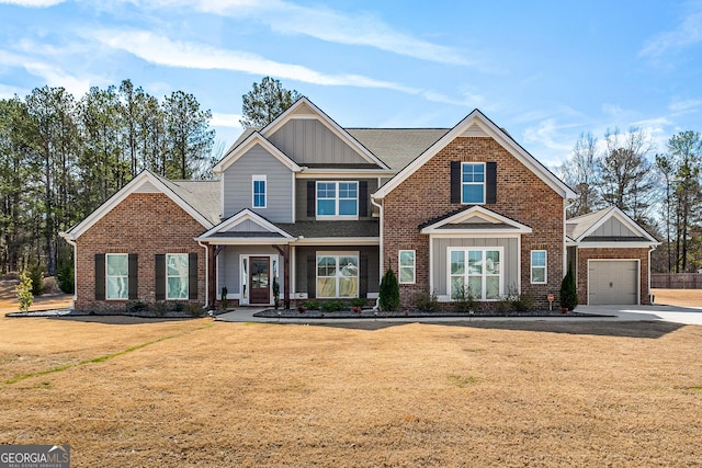 craftsman-style house featuring concrete driveway, an attached garage, a front lawn, board and batten siding, and brick siding