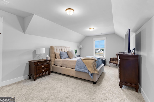 bedroom with lofted ceiling, light carpet, and baseboards