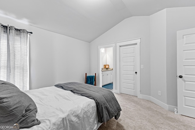 bedroom with lofted ceiling, baseboards, ensuite bath, and carpet