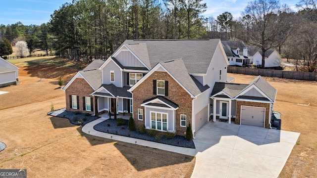 traditional-style home with brick siding, an attached garage, board and batten siding, driveway, and a front lawn