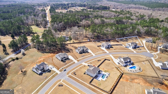 bird's eye view with a wooded view